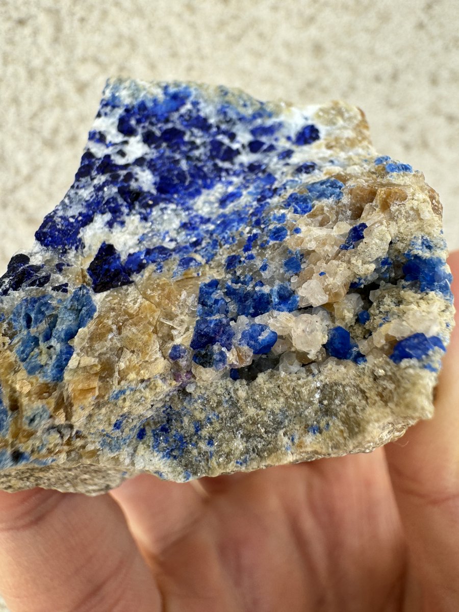 岩石上有一处紫色的矿物,可能是紫方钠石